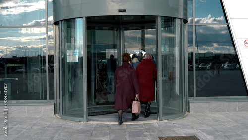 A revolving door in modern building, shopping center. Media. Glass rotating door, turntable entrance to the business center, time lapse.