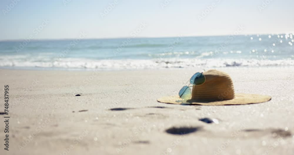 A straw hat and sunglasses rest on a sunny beach with copy space A straw hat and sunglasses rest on a sunny beach with copy space