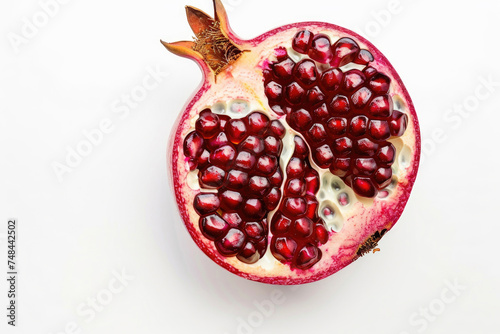 A halved pomegranate revealing jewel-like seeds on white