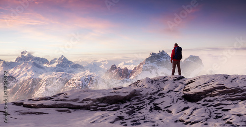 Adventurous Man Hiker on peak. Snowy mountain view. Adventure Composite. 3d Rendering. Aerial Image of landscape from BC, Canada. Sunset