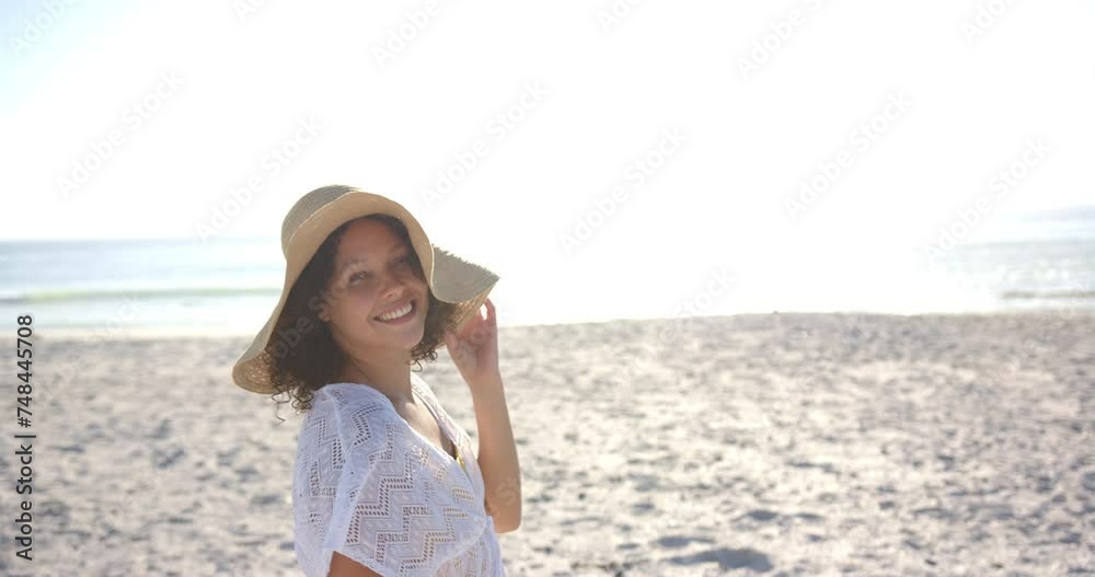 Young biracial woman smiles on a sunny beach, wearing a white dress and a straw hat, with copy space Young biracial woman smiles on a sunny beach, wearing a white dress and a straw hat, with copy space