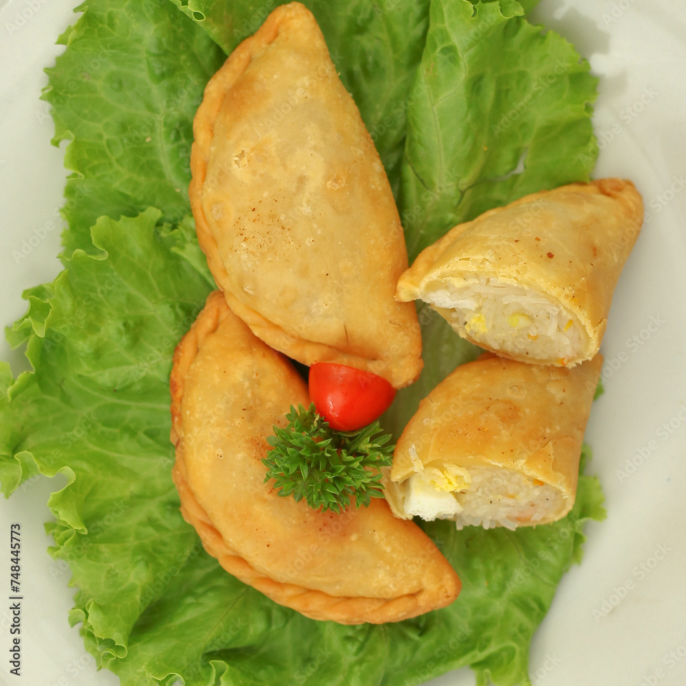 Obraz premium Pastel in Indonesia refers to a type of kue filled with shrimp, vegetables, egg and deep fried in vegetable oil. It is consumed as a snack and commonly sold in Indonesia traditional markets. 