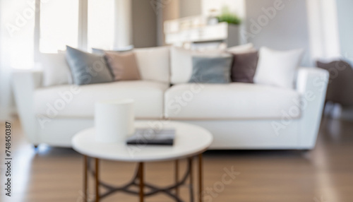 Blurred view of living room interior with white sofa, armchair and coffee table  selective soft-focus  abstract creative background © Uuganbayar