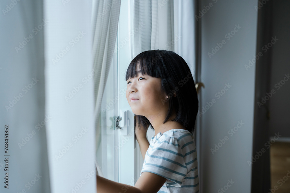 窓の外を眺める日本人の女の子