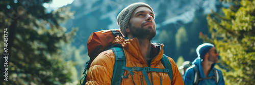 A thoughtful male hiker in a warm jacket pauses to enjoy the serenity of the mountainous forest around him. © Centric 