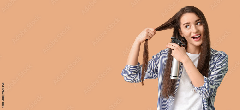 Obraz premium Beautiful young woman using hair spray on beige background with space for text