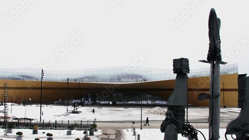 Snow-covered Helsinki Central Library Oodi, modern architecture, winter day, statues in foreground photo