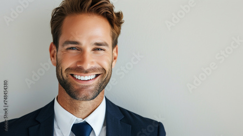 Against a crisp white background, a charmingly smiling businessman with a friendly presence and professional demeanor makes an impression
