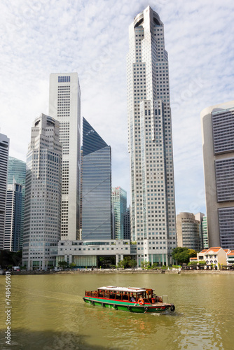 Bumboat on the Singapore river with the tall buildings of the financial district behind photo