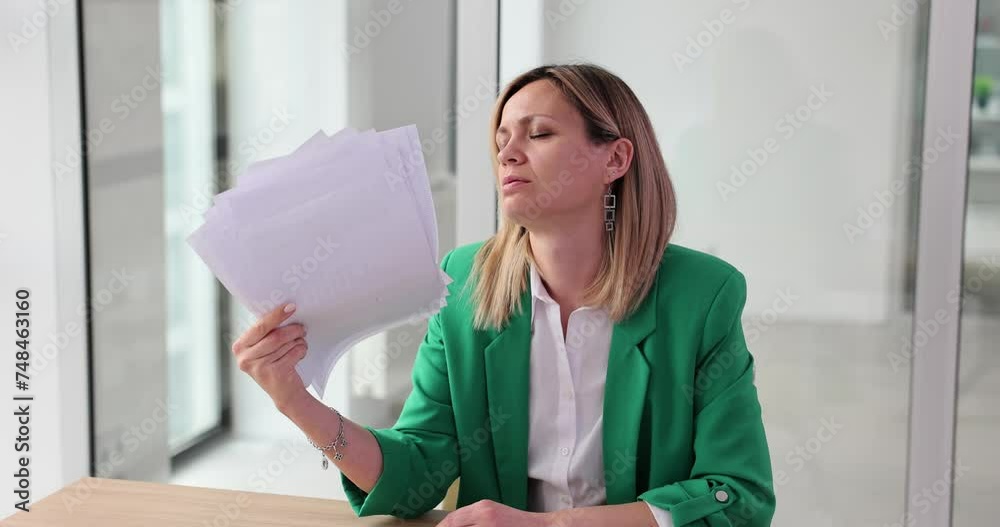 Woman with documents suffers from heat in office Woman with documents suffers from heat in office