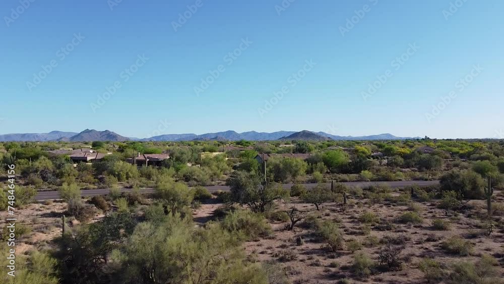 Houses in desert during hot, dry morning sunrise with cacti and desert flora Houses in desert during hot, dry morning sunrise with cacti and desert flora
