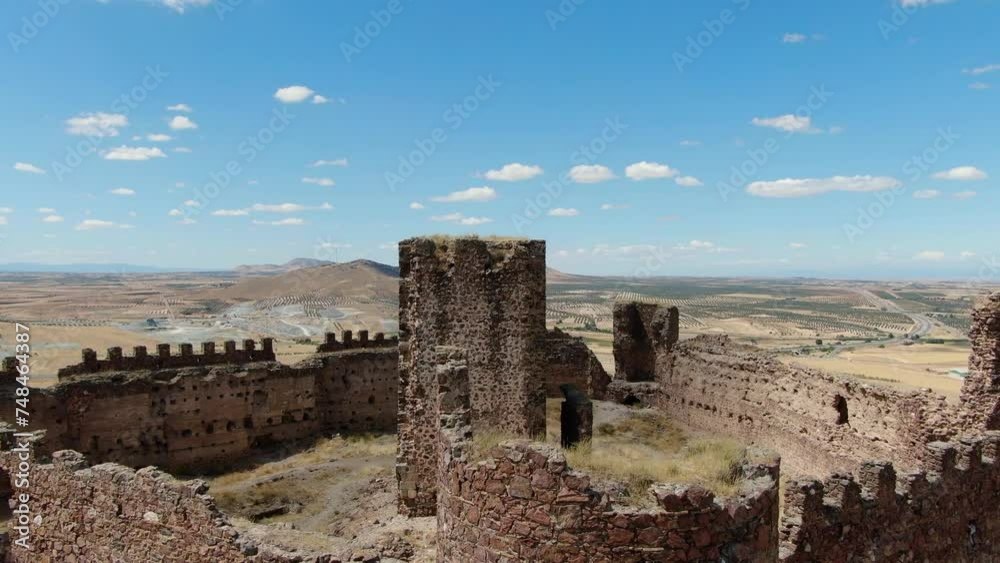 flight in a ruined castle with its walls and towers seeing the main tower with a panning of the camera it is in the middle of the fortress and with crop fields and a town on a summer Toledo Spain flight in a ruined castle with its walls and towers seeing the main tower with a panning of the camera it is in the middle of the fortress and with crop fields and a town on a summer Toledo Spain