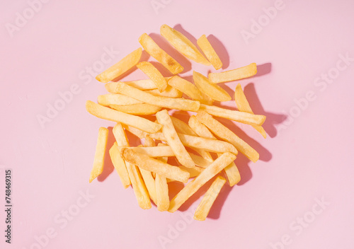 Tasty french fries on pink background