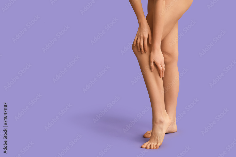 Beautiful young woman after depilation of legs on purple background, closeup Beautiful young woman after depilation of legs on purple background, closeup