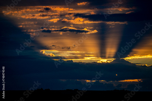 Dark dramatic sunset with rays photo