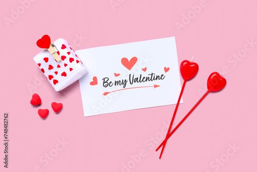 Composition with greeting card, gift box and candles for Valentine's Day celebration on pink background