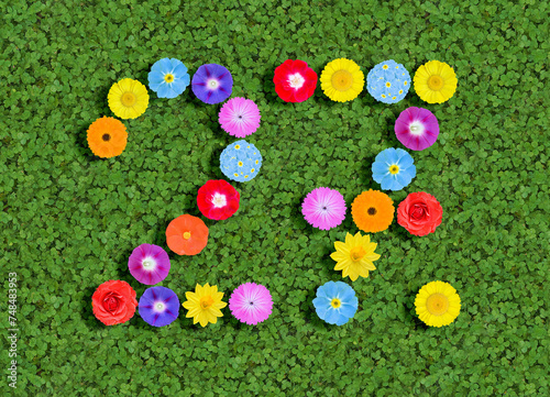 number written with colorful flowers on green clover background photo