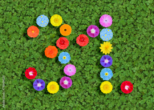 number written with colorful flowers on green clover background photo