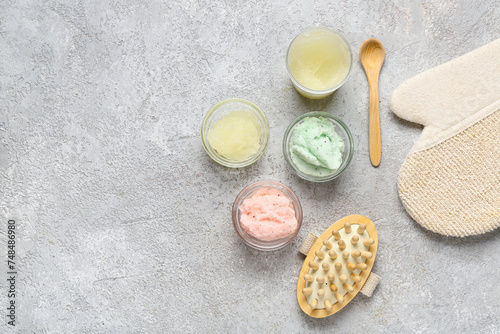 Composition with different body scrubs and bath supplies on grunge background