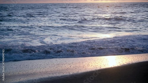 Slow-motion footage of the Pacific Ocean at a beach at sunset in San Deigo, California. photo