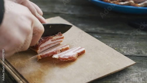 Tourist cuts bacon in nature. Concept of rest and leisure for the weekend.