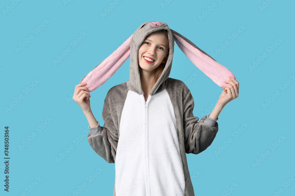 Beautiful young happy woman in bunny costume on blue background. Easter celebration Beautiful young happy woman in bunny costume on blue background. Easter celebration