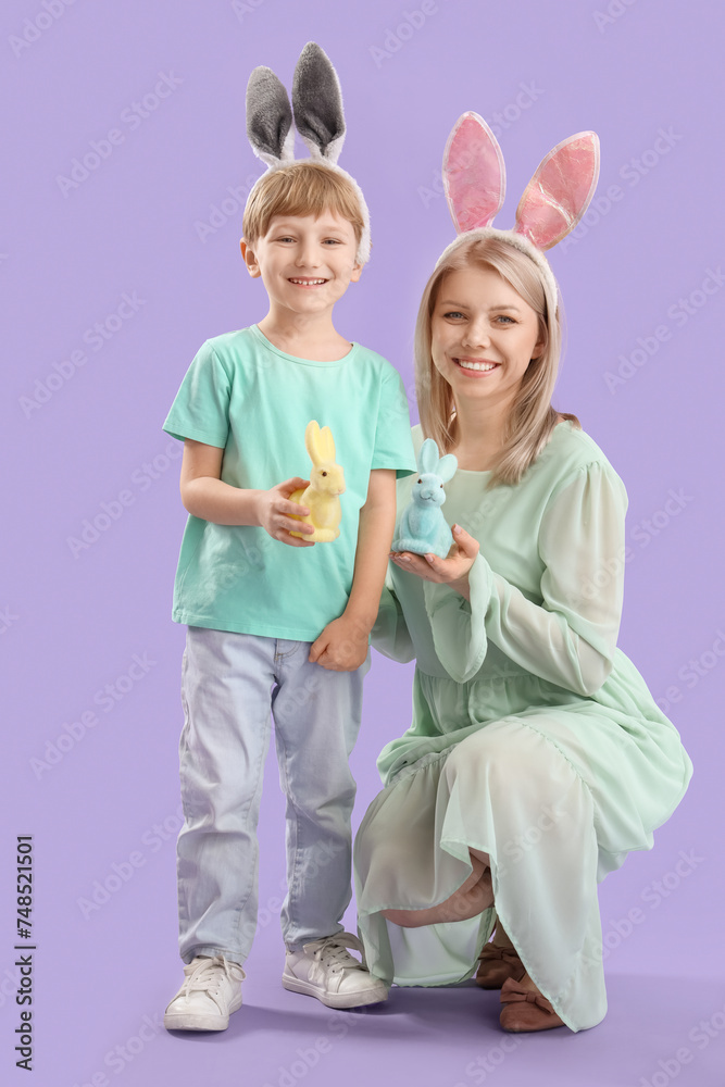 Little boy and his mother with Easter rabbits on lilac background Little boy and his mother with Easter rabbits on lilac background