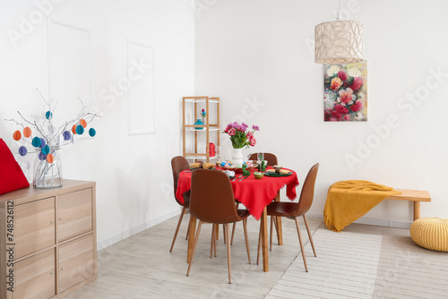 Modern interior of festive decorated dining room with Easter dining table  chest of drawers and chairs