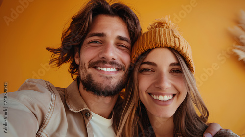 Happy couple taking selfies on yellow background They both smiled happily.