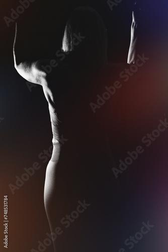 Blonde woman in her mid-fifties training in the gym, photo with flash against a black background. photo