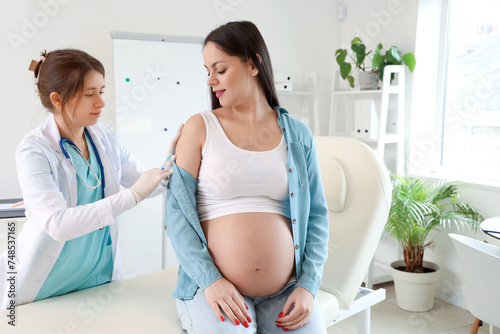 Young pregnant woman receiving vaccine in clinic