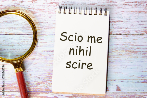 Scio me nihil scire It is translated from Latin as I know I don't know anythingit is written on the page of the notebook photo