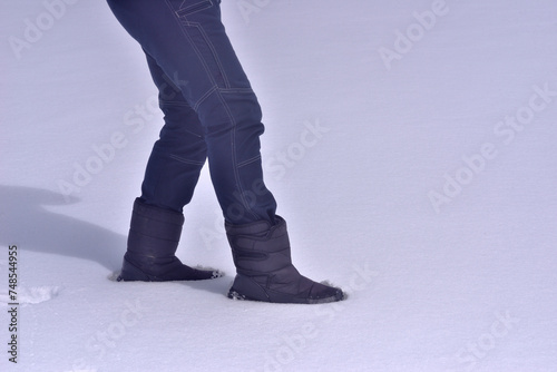 雪の上を歩く男性の足元