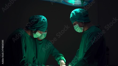 Team of surgical doctor performing a surgery in operating room. photo