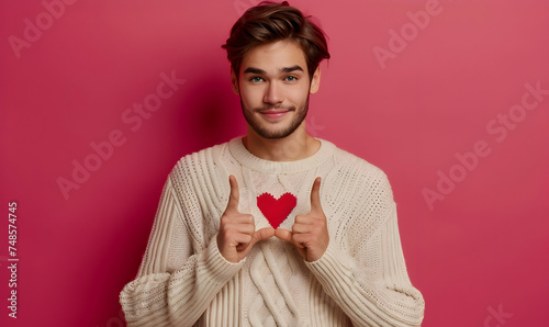 Photo handsome man makes love sign, expresses tender feelings, healthy skin, wears sweater, has romantic mood
