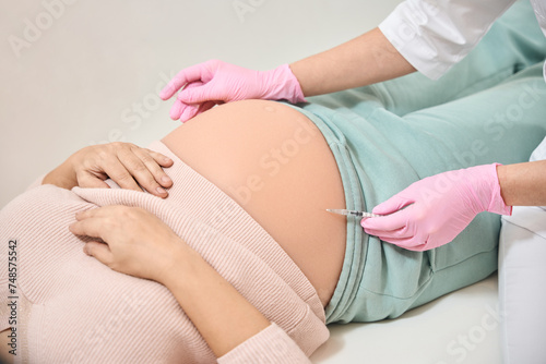Gynecologist making Rh immunoglobulin injection into belly of pregnant woman © Svitlana