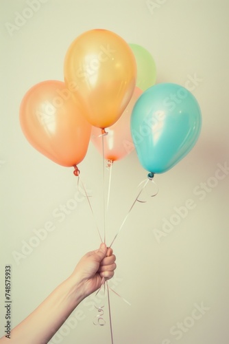 A person holding a bunch of colorful balloons. Suitable for celebrations and events