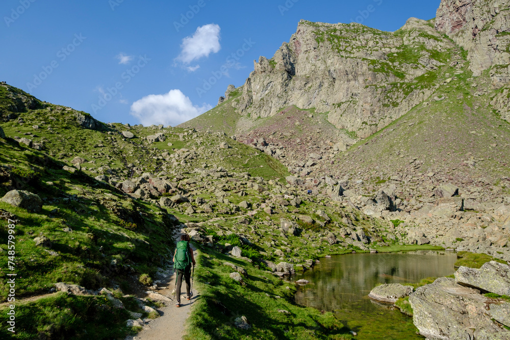 hiker on Lac Bersau, Ayous lakes tour, Pyrenees National Park, Pyrenees Atlantiques, France hiker on Lac Bersau, Ayous lakes tour, Pyrenees National Park, Pyrenees Atlantiques, France