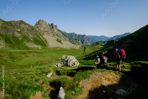 hikers descending into the valley, Col de Souzon, Midi d'Ossau peak, 2884 meters, Pyrenees National Park, Pyrenees Atlantiques, France photo