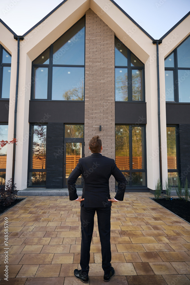 Back view photo of man standing in front of building