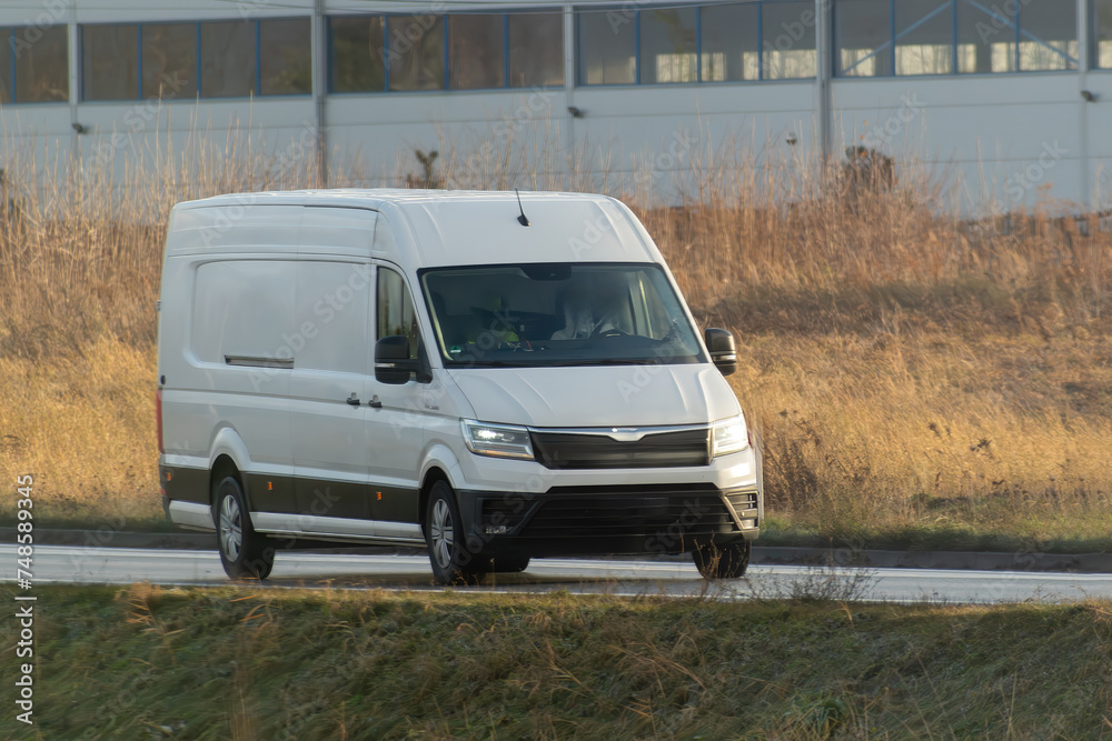 A white van with a blank wrap for your business branding and delivery service. Isolated mockup of a commercial vehicle on the road.