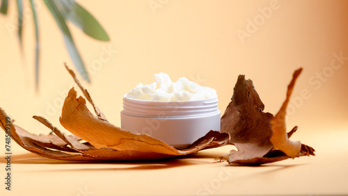 Shea butter in a white bowl on light beige background. Product moisturizer natural for beauty, cosmetics and spa. photo