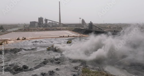 Aerial. Cement factory spewing out toxic pollution emitting harmful sulfur dioxide, nitrogen oxide and carbon monoxide into the atmosphere photo