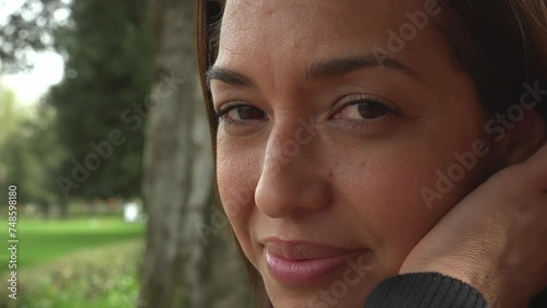 Playful Radiance: Hispanic Woman's Joyful Smile and Hair Caress photo
