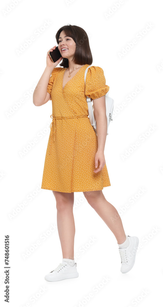 Happy woman with backpack talking on smartphone against white background Happy woman with backpack talking on smartphone against white background