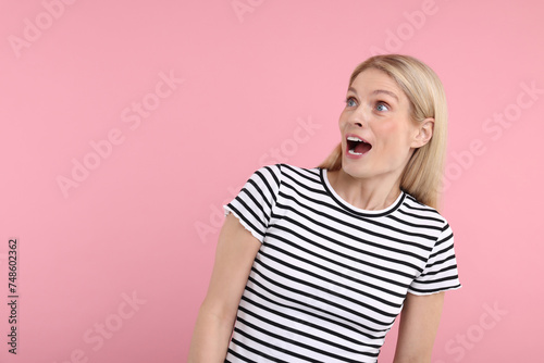 Portrait of surprised woman on pink background, space for text © New Africa