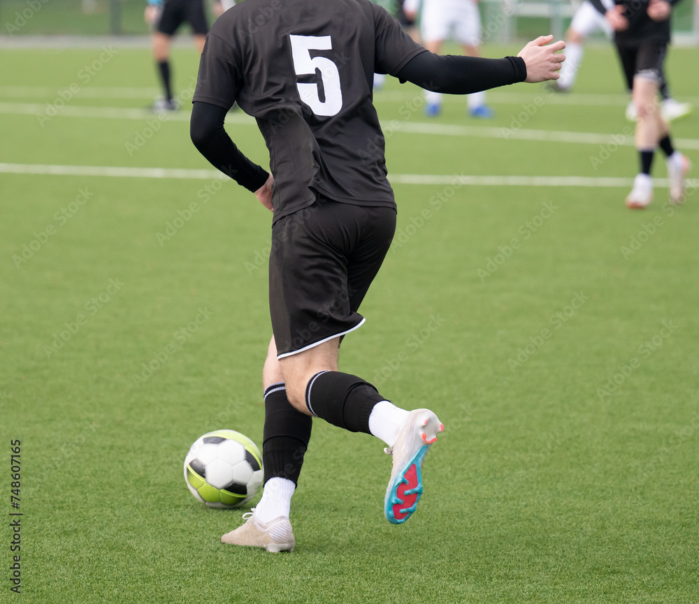 Fußballspieler, die dem Ball hinterherlaufen