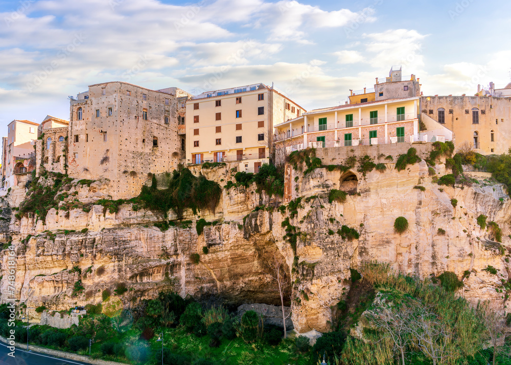 scenic travel landscape of beautiful historic town Tropea in Italy with old antique buildings, vintage houses on a high rock cliff above sea and amazing blue sky on background