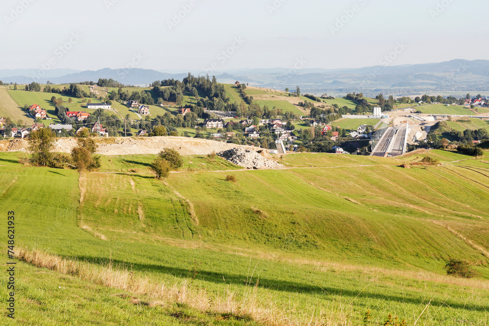 KLIKUSZOWA, POLAND - JULY 19, 2023: Fields and meadows and construction of a new section of the S7 route near Nowy Targ, Poland.