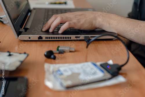 Process of installing laptop hard drive disk and data transfer, Precision installation: Technician expertly repairs and installs a laptop hard disk for seamless performance